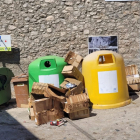 Imatge d’alguns contenidors buits mentre els residus de cartró s’acumulen al carrer.