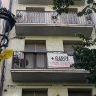 La pancarta '+ barri - pisos turístics' en un balcó de la Rambla de Girona