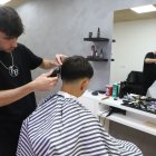 Arnau Farré, el barber de 20 anys que ha obert el seu negoci a les Borges, ahir amb un client. - MAGDALENA ALTISENT