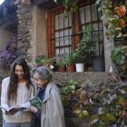 Teresa Ticó Marquès, de Casa Micàs de Lladorre, fulleja les pàgines del llibre amb Joana Blanch.