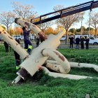 Els operaris carreguen les peces de l'escultura a un camió ploma per traslladar-la.