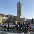 Un grup de corredors enfila la baixada després de donar-se la sortida, amb l’emblemàtic monument lleidatà al fons. - INGRID SEGURA