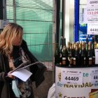 Una treballadora de l'adminstració de loteria del centre comercial Arenas de Barcelona preparant ampolles de cava per celebrar que el local ha repartit un premi del Nen en una imatge d'arxiu.