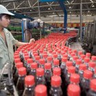 En la imagen de archivo, un trabajador comprueba las botellas de refresco en la línea de control de calidad de la embotelladora de Hangzhou, China.