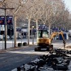 Una màquina perforant el paviment per a l'ampliació de la vorera.