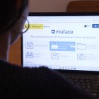 Una persona mirant la pàgina web de Muface.