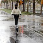 Una conductora de patinet elèctric circulant amb casc en les primeres hores de la nova ordenança de circulació a Barcelona