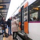 Diversos passatgers pujant en un tren a l'estació de Bellvitge-Gornal que va direcció Barcelona.