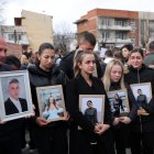 Familiars amb fotos dels seus éssers estimats morts en l’incendi durant una protesta a Skopje. - EFE/EPA/GEORGI LICOVSKI