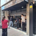 Diverses persones intentaven abaixar manualment una reixa automàtica d’un negoci de l’Eix Comercial. - S. COSTA D.