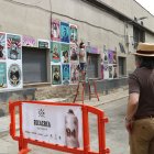 Un dels artistes treballant al seu mural. - ACN