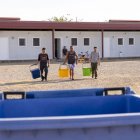 Treballadors de temporada de l’alberg d’Alcarràs a l’esplanada veïna amb cubells de la selectiva. - MAGDALENA ALTISENT