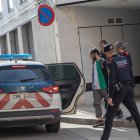 Investigadors dels Mossos d’Esquadra a la sortida del domicili escorcollat al carrer Indústria. - LAIA PEDRÓS