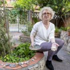 La veïna mostra un objecte decoratiu del seu jardí trencat per una pedrada, amb altres pedres al costat. - JORDI ECHEVARRIA