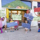 Famílies, davant la ludoteca amb algunes de les pancartes que preparen per a la protesta. - JORDI ECHEVARRIA