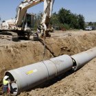 Operaris instal·lant un tub de reg en el marc dels treballs de modernització del canal de Pinyana, a Alguaire