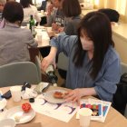 Una visitant a l'Expo d'Osaka fent el taller de pa amb tomàquet