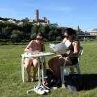 Estudiants de la UdL van aprofitar ahir per prendre el sol i estudiar a la canalització, malgrat la calor. - ACN / ROGER SEGURA