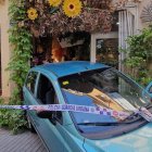 El cotxe, abalisat per la Guàrdia Urbana, després de xocar marxa enrere contra l'aparador de la floristeria
