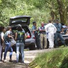 Els agents investiguen la troballa dels cossos en un cotxe. - EFE/ XOÁN REY
