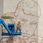 L’artista Oriol Arumí, ahir al mural que està pintant amb la imatge de Jorge Delgado a Balàfia