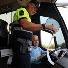 Un agent, revisant un dels busos que van portar estudiants ahir a la zona de la Serra. - J.GÓMEZ