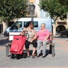 Dos dones conversen en un banc en una plaça de Balaguer.