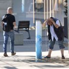 Una persona refrescant-se ahir en una font de Lleida. - AMADO FORROLLA