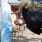 Un vianant es refresca en una de les fonts dels carrers de Lleida. - MAGDALENA ALTISENT