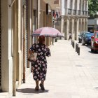 Una mujer se protege del sol con un paraguas este mediodía en Lleida.