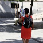 Una vianant es protegeix del sol a Lleida.