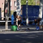 Dos persones netejant-se a la font que han habilitat al costat del pavelló 3 que fa d’alberg. - JORDI ECHEVARRIA