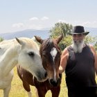 Pere Cases, amb dos dels cavalls retirats que cuida al seu refugi de Montcortès. - MARTA LLUVICH/ACN