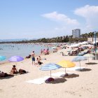 Turistes i banyistes prenent el sol i banyant-se a la platja de Salou