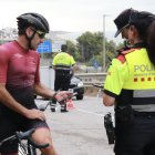 Un ciclista mostra la seva documentació als Mossos d'Esquadra en un control de trànsit.
