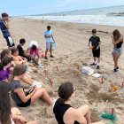 Joves a la platja fent tasques de conservació del medi ambient