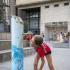 Una nena es refrescava ahir en una font a Lleida. - GERARD HOYAS