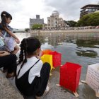 Unes nenes observen al riu Motoyasu els fanalets de paper en memòria de les víctimes de l’atac nuclear. - EUROPA PRESS