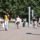 Vianants caminant per Lleida durant el primer dia d'onada de calor