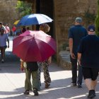 Persones amb parasol pel Turó de la Seu Vella de Lleida.