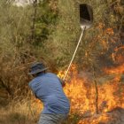 Un veí treballa en tasques d’extinció de l’incendi forestal de Cualedro (Ourense). - EFE/ BRAIS LORENZO
