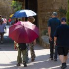 Ciutadans passejant sota paraigua en plena onada de calor aquest agost a Lleida ciutat. - GERARD HOYAS