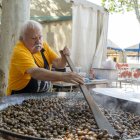 Un cocinero preparando una gran paella de caracoles a la gormanta.