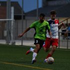 Un futbolista de l’Alpicat avança amb la pilota sota pressió.