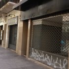 Locals buits, amb pintades al reixat, a l’Eix Comercial. - MAGDALENA ALTISENT