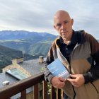L’escriptor Albert Villaró amb el seu últim llibre, en un balcó d’Estamariu des del qual es veu el Cadí. - ACN / ALBERT L. COBO