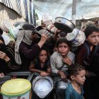 Nens gazians demanen menjar al camp de refugiats de Nuseirat, al centre de l’enclavament. - EUROPA PRESS