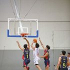 Pol Ríos intenta anotar davant de la defensa de dos rivals.