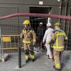 Bombers acompanyen dos veïns a l’interior de l’edifici. - ACN