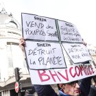 Una persona sostiene un cartel durante una manifestación contra la apertura de la primera tienda física de Shein en el edificio BHV en París.